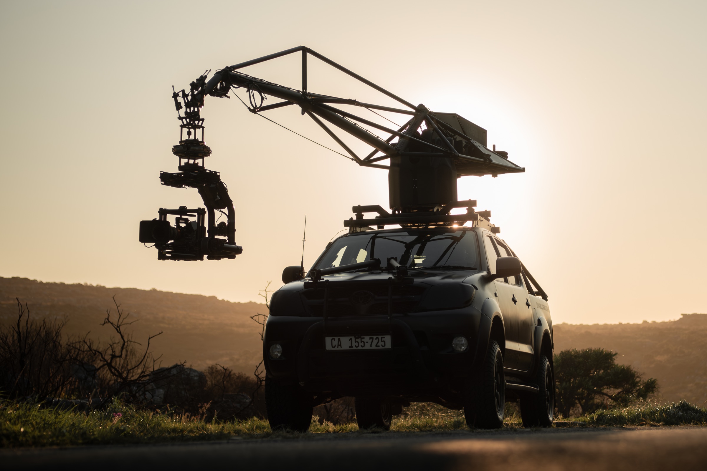 Dragon camera crane mounted on a tracking vehicle at sunset
